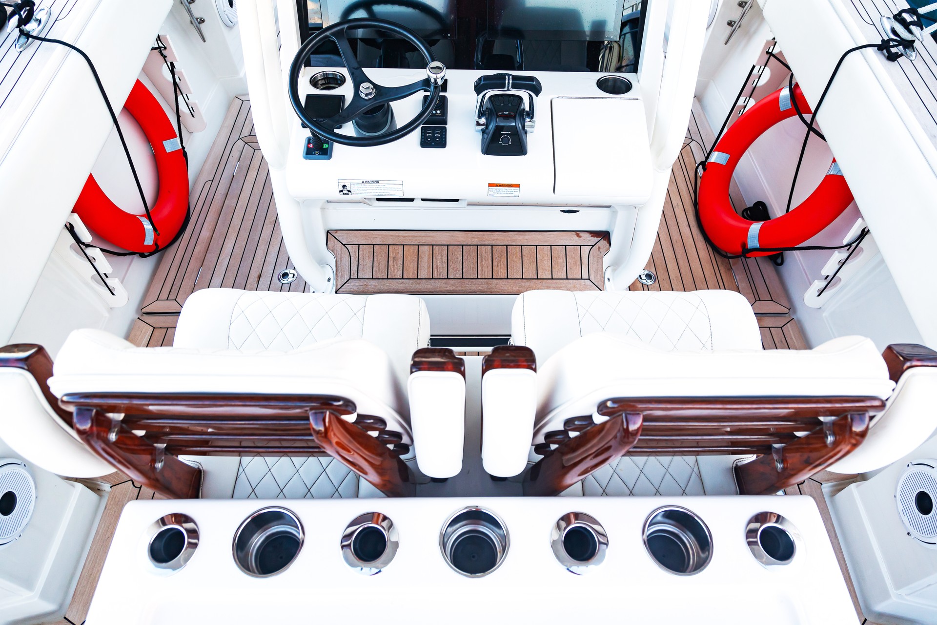 Luxurious boat control cabin with white leather seats, steering wheel, gear lever and on-board computer. Luxurious boat control cabin with white leather seats, steering wheel, gear lever and on-board computer.